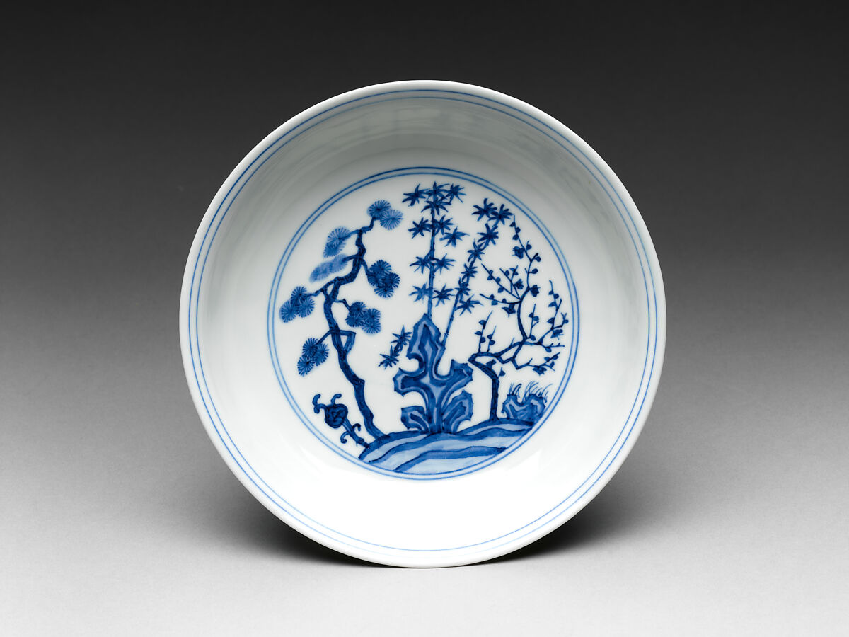 This blue and white plate h
as stylised illustrations of pine, bamboo and plum blossom painted onto it.